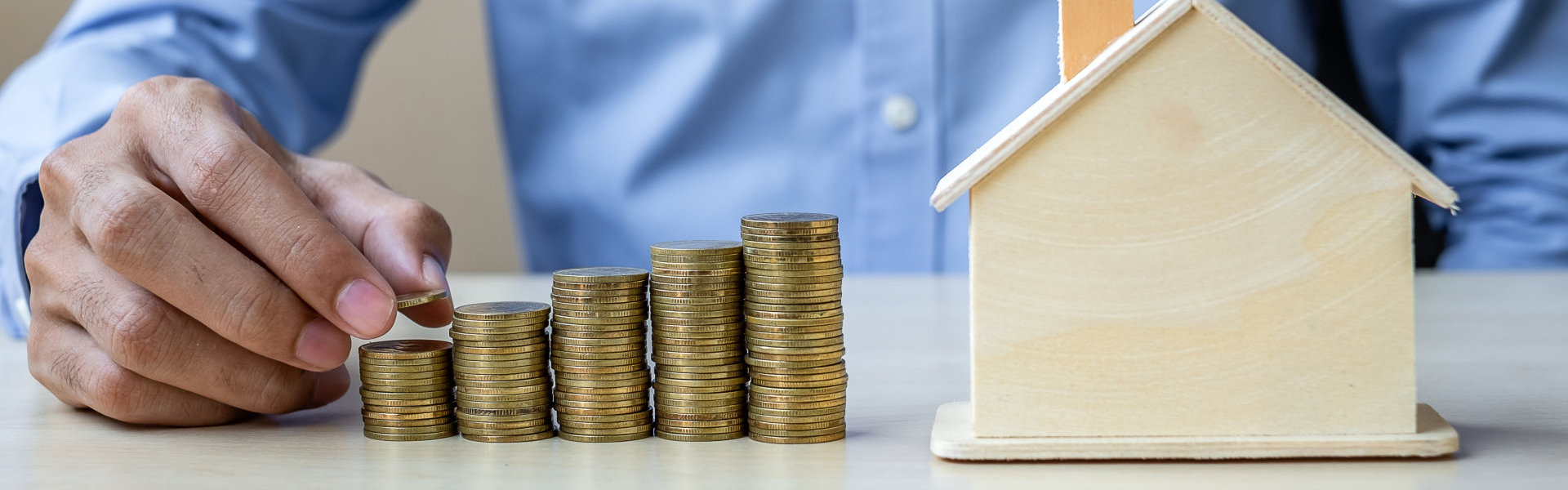 a pile of coin with a miniture house